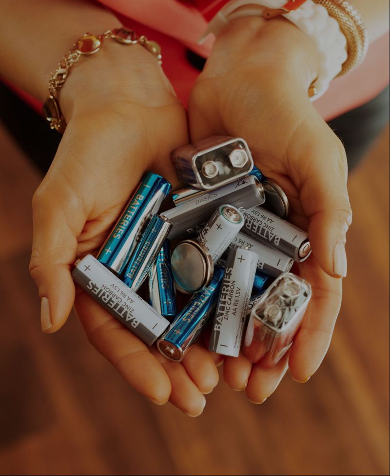 Hands holding used batteries